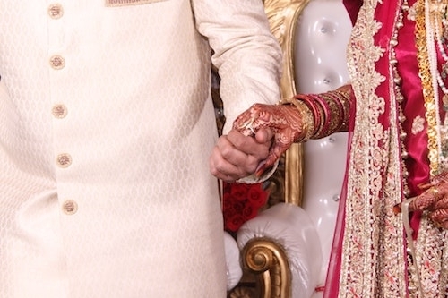 bride and groom closeup holding hands in Indian wedding