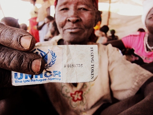 refugee holding UNHCR ticket