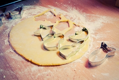 Photo of cookie dough being cut by various molds.