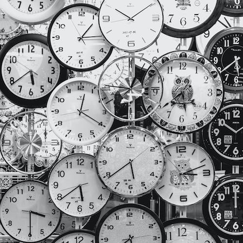 a black and white photo collage of many different, overlapping clock faces with different times