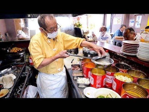 Screen shot of Japanese cook preparing meals in small open kitchen of small Japanese restaurant