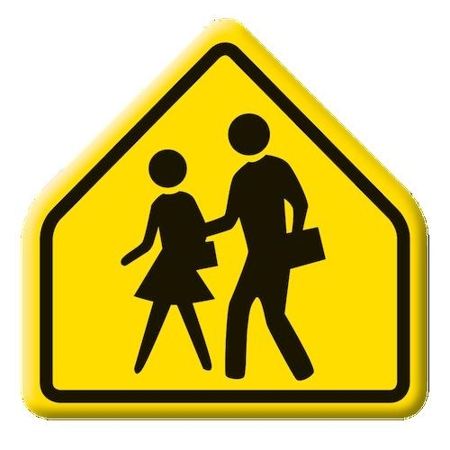 close-up of image on yellow school crossing sign showing black silhouette figures of students walking and carrying books