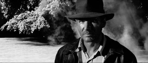 still of Harrison Ford as Indiana Jones in Raiders of the Lost Ark in black and white