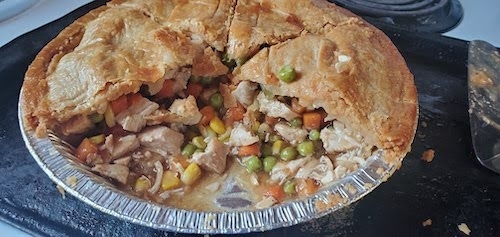 photo of a cut open baked chicken pot in an aluminum pie plate