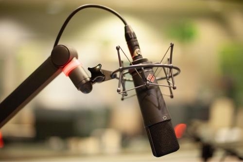 close-up of a vintage microphone against a blurry background of a radio station