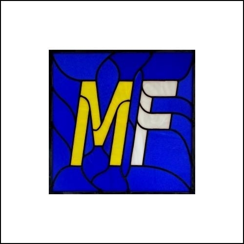 photo of stained glass square with dark blue background and a yellow M and white F in a font style like the Metafilter favicon