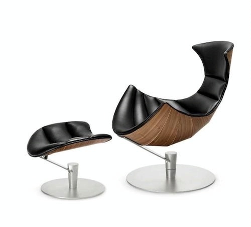 photo of a modernistic black leather and chrome chair with wood veneer with matching footstool
