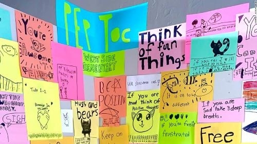 colorful collage of posters with positive messages drawn and written by young students