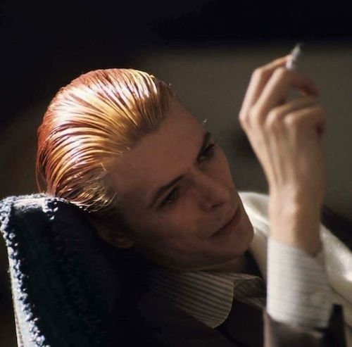 gauzy screen-cap of Bowie head and shoulders elegant smoking a cigarette and looking hungry