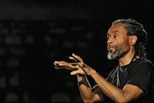 screen capture showing Bobby McFerrin in a black t-shirt against a black background gesturing during his presentation