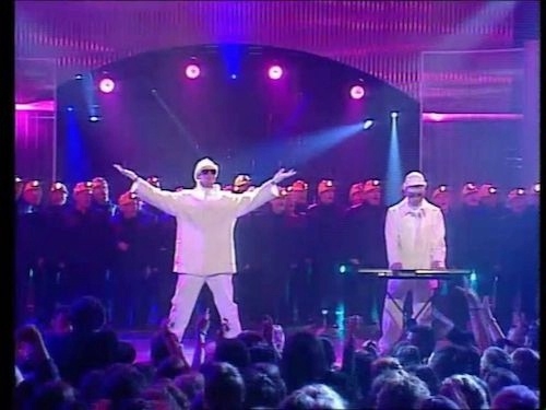 concert image showing Pet Shop Boys performing on stage with miner choir behind them