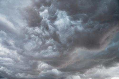 Photo of grey and white billowy fast-moving clouds