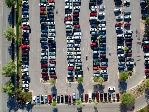 Overhead view of an outdoor parking lot filled with cars