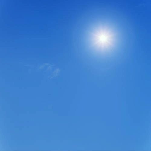 bright burning sun high in an electric blue cloudless sky