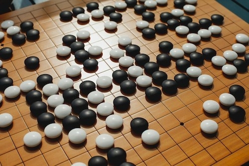 close-up of a Go board game with black and white playing pieces