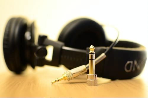 photo of a set of black earphones on a tabletop against a white background