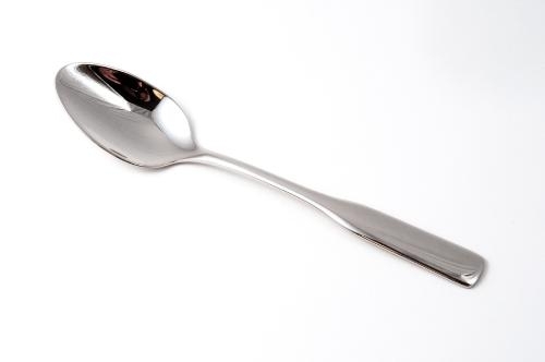 photo of a stainless steel dinnerware spoon against a white background