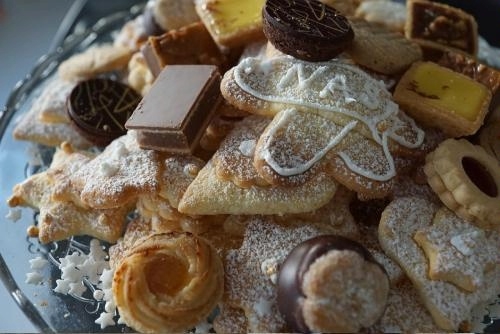 close-up of a glass plate stacked with various kinds of cookies