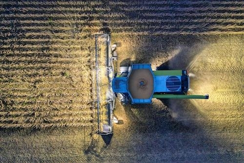 farm tractor harvesting a large field